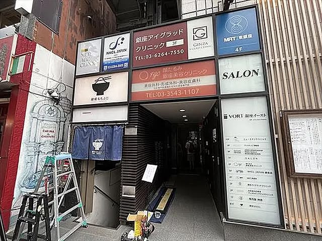 Photograph showing the exterior entrance and building directory where NEW AGE CLINIC signage is visible