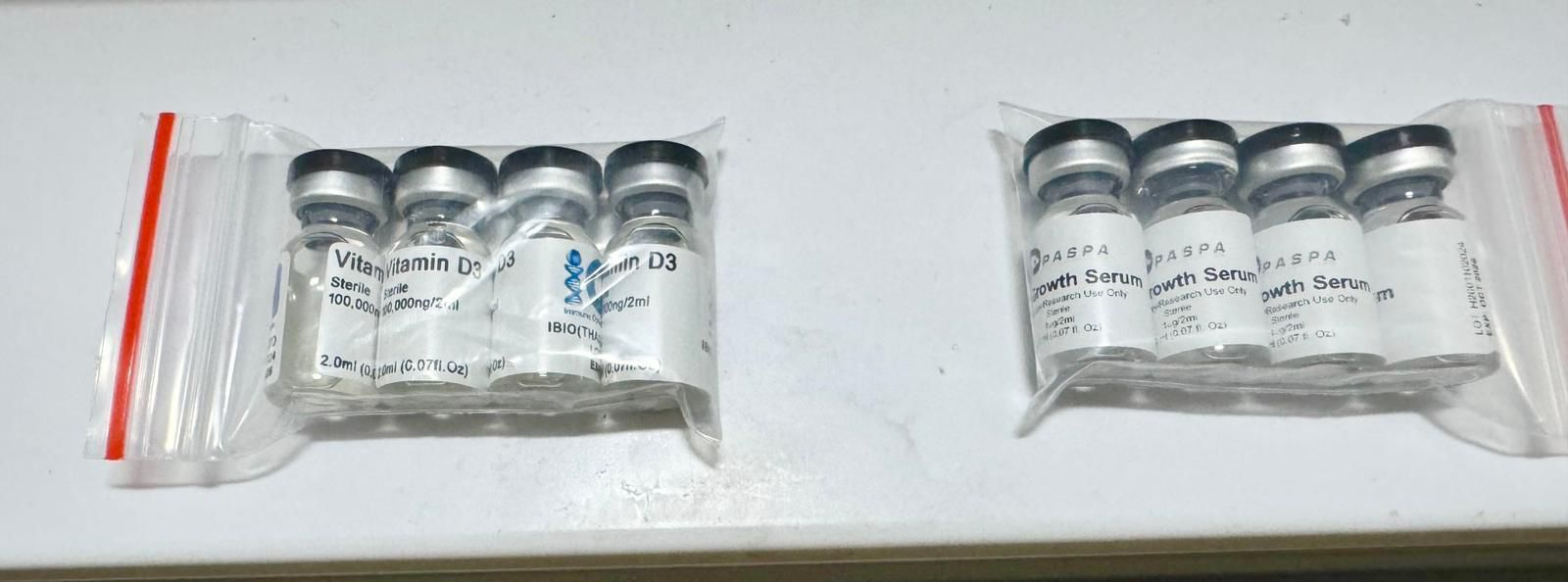 Supplied photograph showing Vitamin D3 vials and PASPA Growth Serum vials labeled For Research Use Only